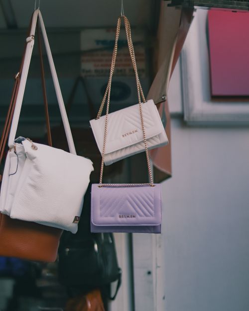 Free A collection of stylish leather handbags hanging in an outdoor market stall. Stock Photo
